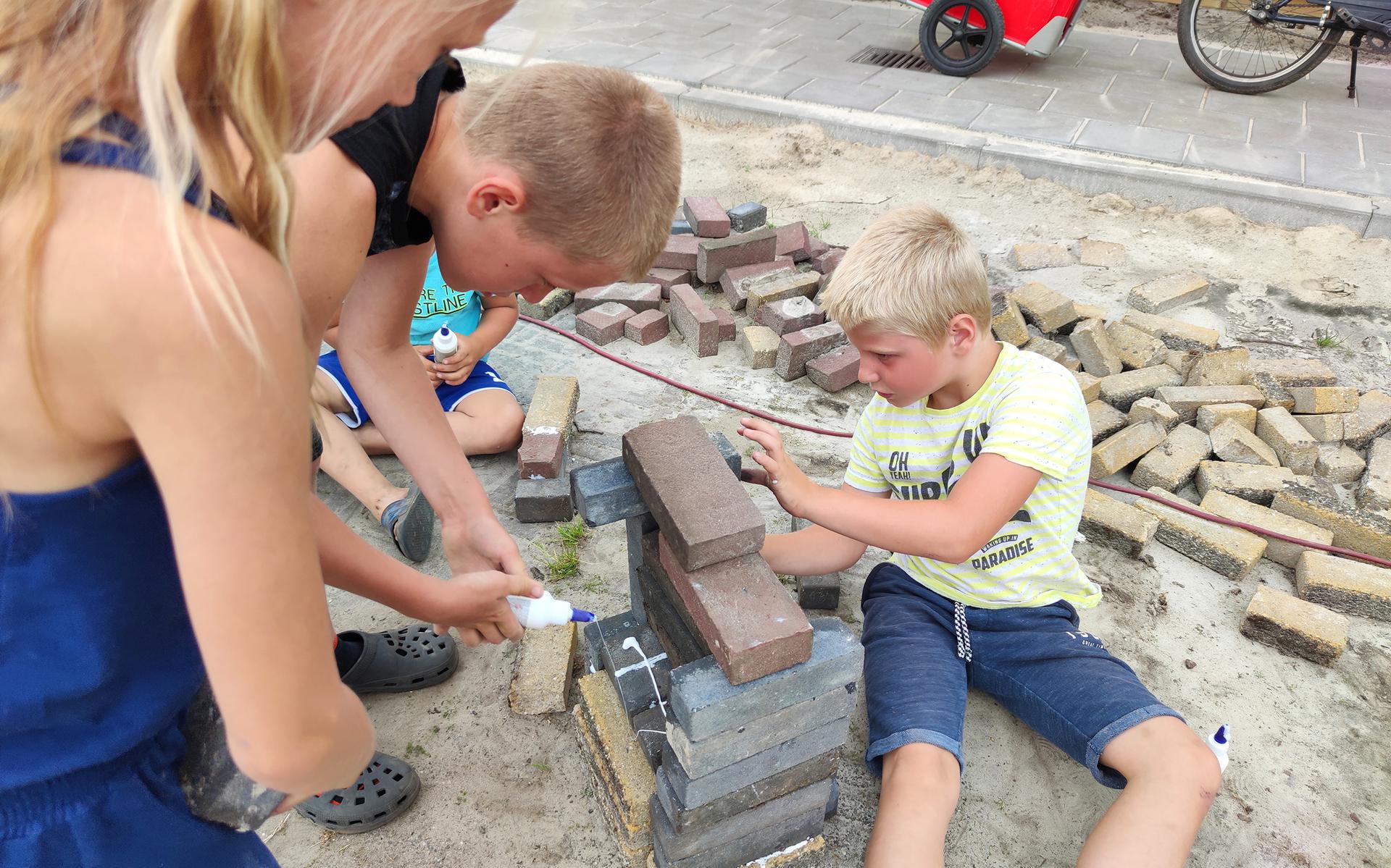 Kinderen maken bouwsels tijdens de buurtlunch op het Ketelhuisplein in het Haerenkwartier.