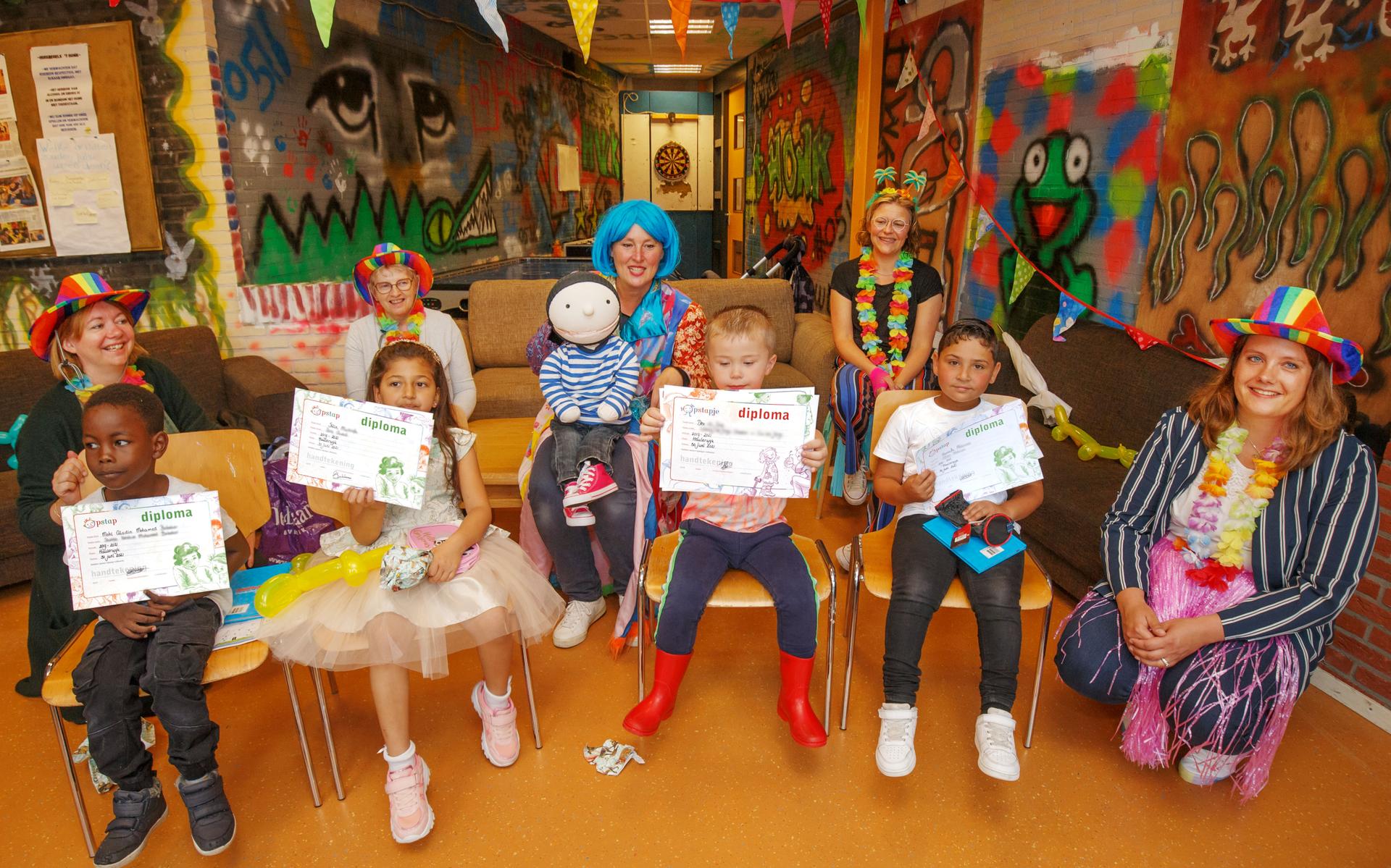 De vier kinderen die in Haulerwijk hun diploma ontvingen, samen met Stapmedewerkers.