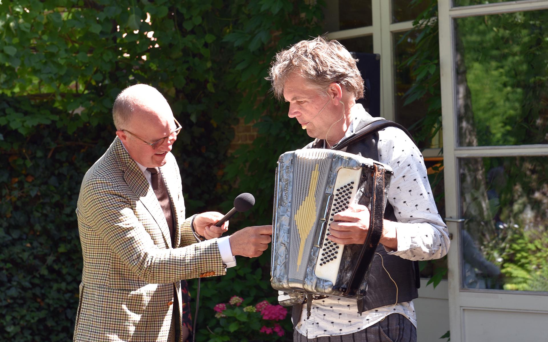 Commissaris van de Koning Brok opende de jubileumeditie van Open Stal door een toets van het accordeon van voorzitter Peter Hoekstra in te drukken