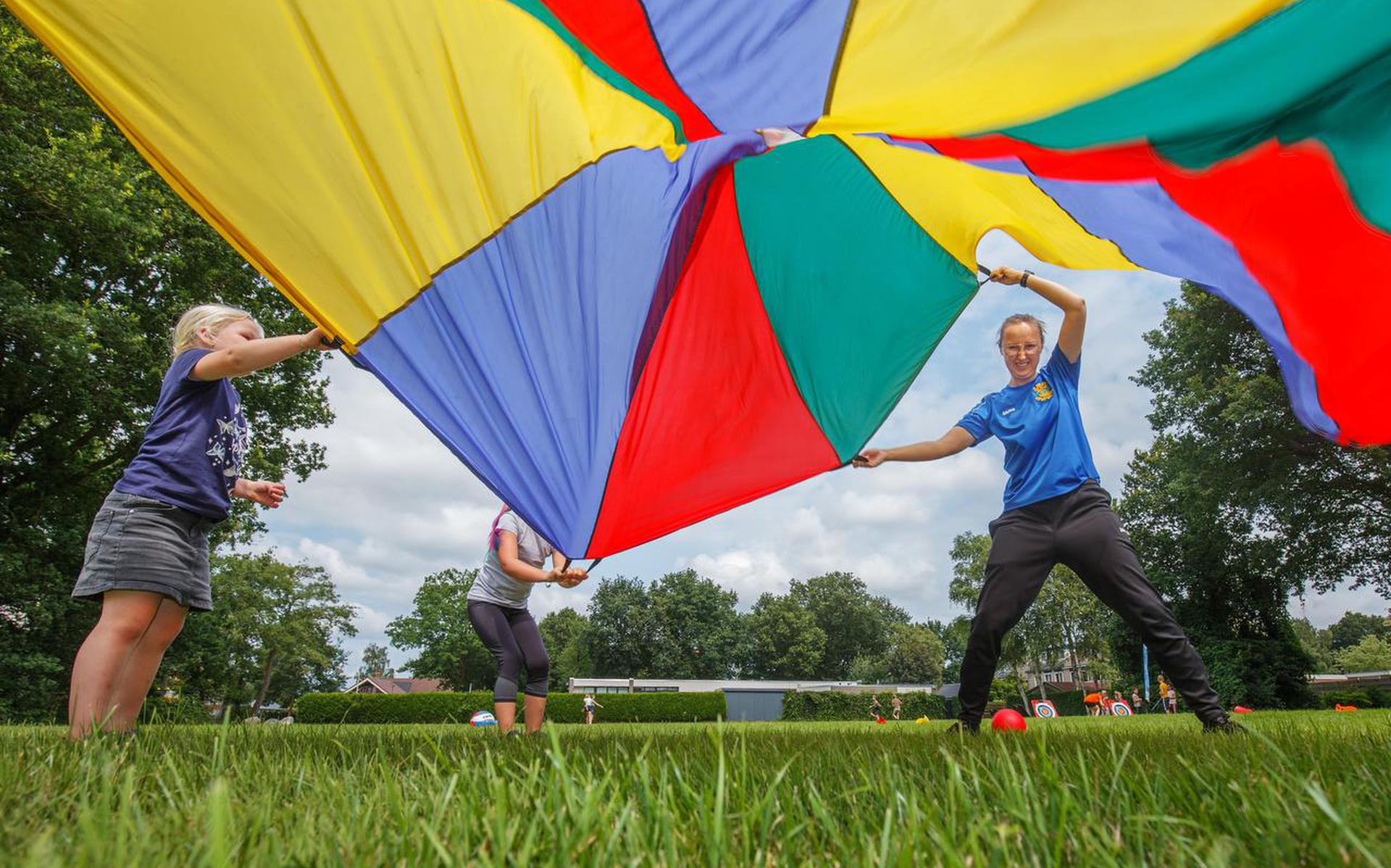 Buurtsportcoach Anouk Pothoven houdt probeert samen met kinderen een bal hoog te houden. 