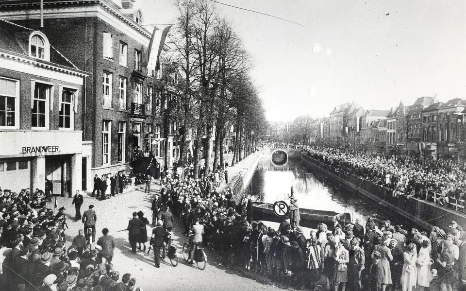 Een menigte aanschouwt het opbrengen van NSB-ers en collaborateurs naar het politiebureau van Leeuwarden op 16 april 1945.